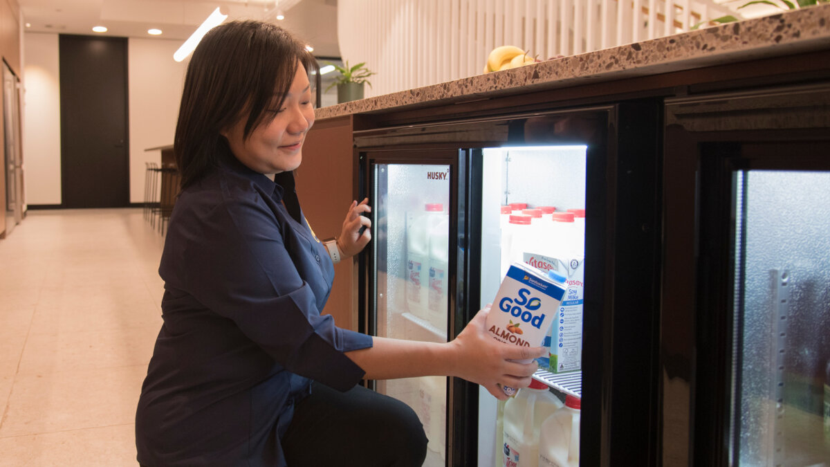 BrewHub Valet restocking a fridge with almond milk