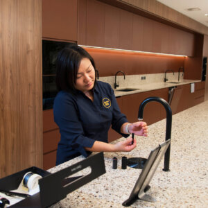 BrewHub valet in a client workplace cleaning and servicing the office coffee machine.