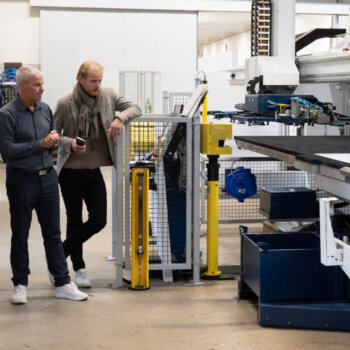 The BrewHub team overseeing a machine on the Scanomat factory floor.